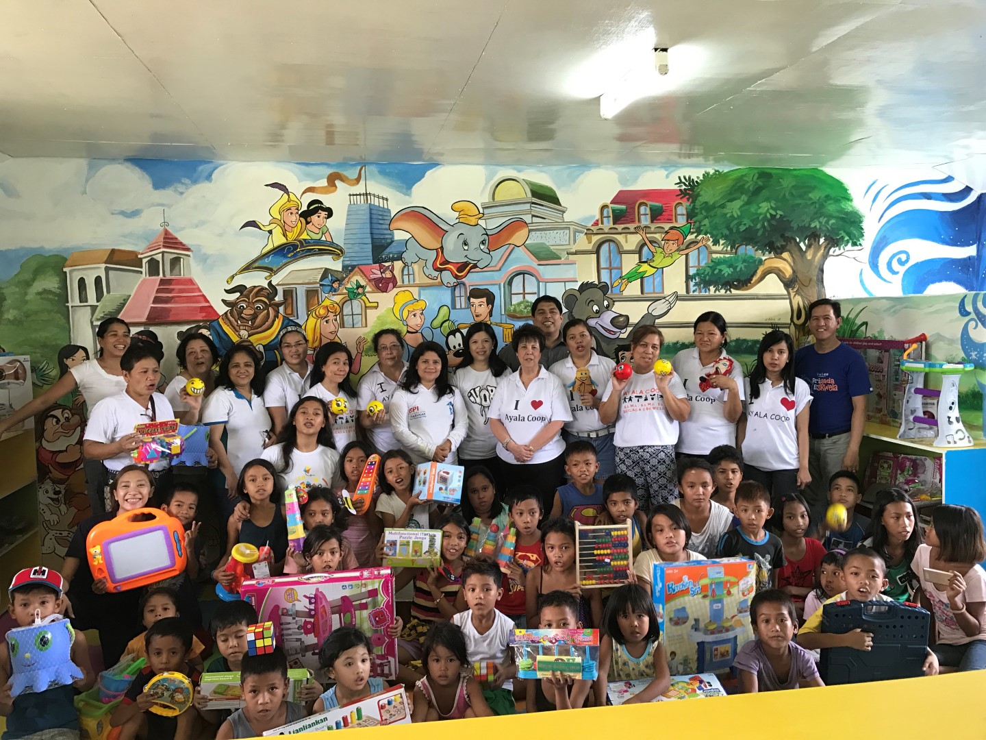 The Coop team is shown with Sta. Cruz Elementary School pupils during the turnover of the toy library to the school.
